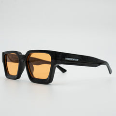 Black sunglasses with orange lenses on a light gray background